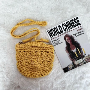 Macro view of ginger yellow crochet handbag showing thick woven strap and popcorn texture