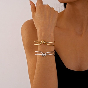 Minimalist double-layer geometric knot open bangle in polished gold and silver finishes