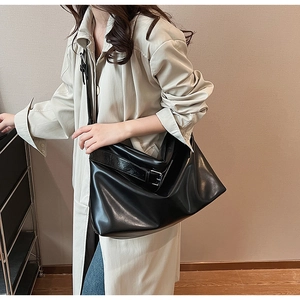 Détail d'un grand sac cabas noir en similicuir avec large bandoulière porté par un mannequin