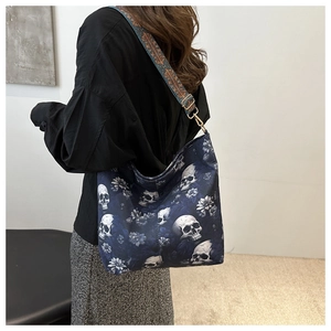 Detail of navy canvas tote with skull print and ethnic style woven shoulder strap