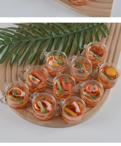 Detailed top view of miniature beef noodle keychains in transparent bowls with varied toppings