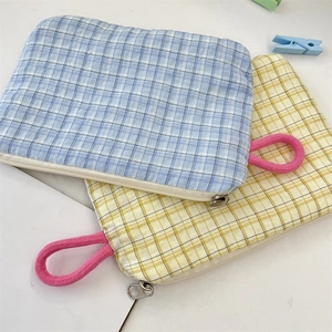 Close-up of checkered small cosmetic pouches with durable pink handles and zippers