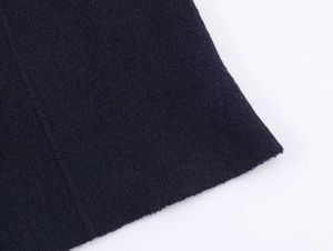 Close-up of deep blue wool blend knit fabric texture and vertical seam stitching details