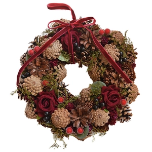 Christmas wreath with natural pine cones, red roses and velvet bow for window decor