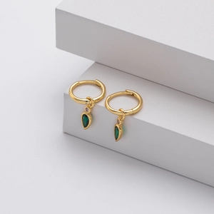 Detail view of gold hoop earrings with green pear-cut gemstone and purple accents