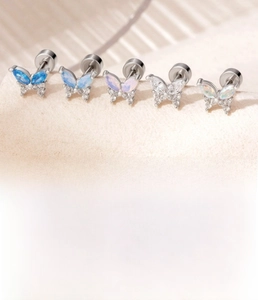 Macro detail of butterfly ear studs with sparkling zircon inlays and titanium steel posts