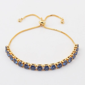 Detail of gold box chain bracelet with blue zircons and adjustable sliding clasp closure