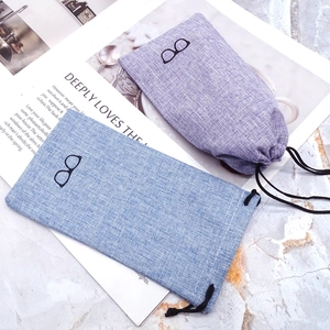 Linen drawstring eyewear pouches in light blue and purple with minimalist glasses logo