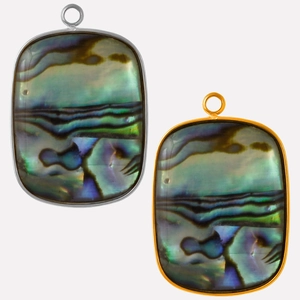 Detailed macro view of oval abalone shell pendants with gold and silver stainless frames