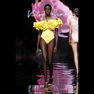 Close-up of bright yellow swimsuit with layered 3D floral petals on the neckline