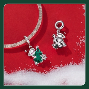 Macro detail of silver Christmas bear charm with green crystal tree on a snake chain