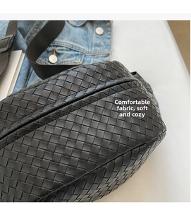 Close-up of black woven leather chest bag with Intrecciato pattern and zipper