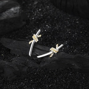Detailed shot of two-tone twisted wire stud earrings with pavé white zircons