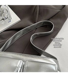 Detail of wide comfortable shoulder strap on a silver metallic faux leather shoulder bag