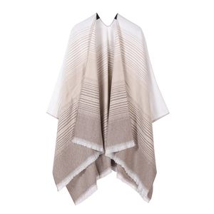 Detail of beige and white gradient knit shawl with striped pattern and fringe edges