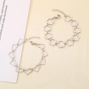 Detail of silver hollowed heart and flower link bracelets with lobster clasp and chain