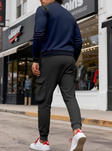 Dettagli della giacca blu scuro con colletto e pantaloni cargo neri stile street
