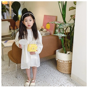 Detail of yellow mini bag with pearl handle and golden chain strap for girls