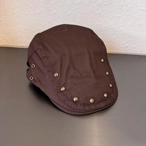 Detailed macro view of dark brown retro flat cap with metal rivets and side eyelets