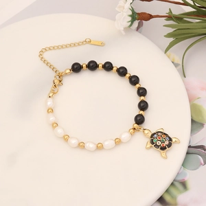Gold-tone bracelet with black onyx, white pearls and a colorful sea turtle pendant