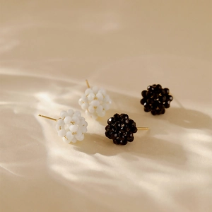 Macro detail of bead stud earrings in black and white with 18K gold plated posts