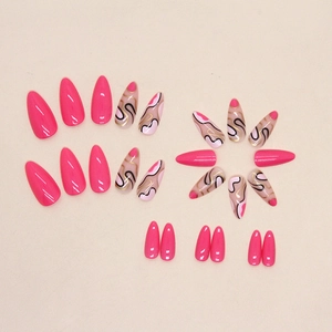 Long almond press-on nails in Barbie pink with black and gold wavy geometric patterns