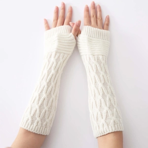 Macro view of cream knit arm warmers showing detailed cable stitch texture and thumb hole