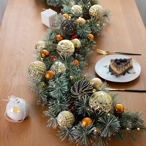 135cm Christmas garland with pine needles, gold ornaments and red berries on a wooden table