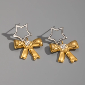 Dettaglio di orecchini a fiocco in oro 18K con stelle d'argento e intarsio di cristalli