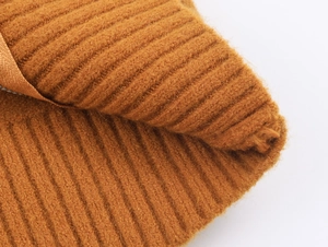 Gros plan sur la maille épaisse caramel avec motif à côtes verticales d'un cardigan doux