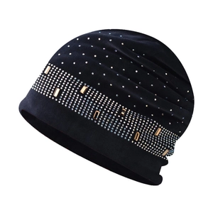 Détail du bonnet en tricot chenille noir orné de strass et de pièces en métal doré