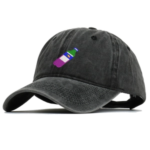 Detailed close-up of charcoal washed cotton baseball cap with embroidered bottle design