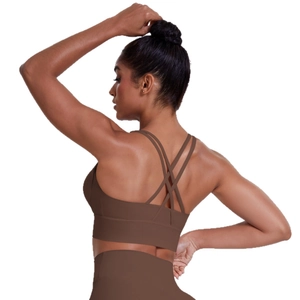 Deep brown sports bra with criss-cross back straps and high-waist yoga leggings