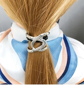 Silver metal knot hair tie with polished finish shown on a blonde ponytail hairstyle