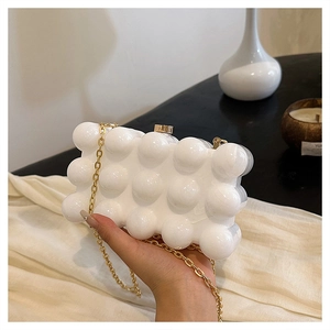 Détail du sac boîte en acrylique blanc perle avec texture bulles 3D et chaîne dorée