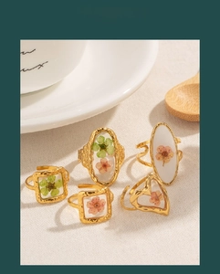 Set of gold stainless steel rings featuring real preserved flowers in textured resin