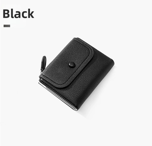 Detail of black litchi texture on women's compact tri-fold wallet with snap closure