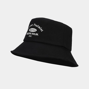 Close-up of white embroidered fashion lettering on a black cotton bucket hat surface