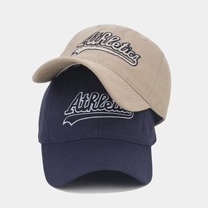 Detail of Athletics embroidery on khaki and navy blue twill cotton baseball caps