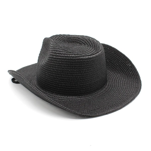 Dettaglio cappello cowboy in paglia nera con tesa larga ricurva e sottogola regolabile