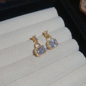 Detail view of gold rectangular zircon lock earrings with micro-pave crystals