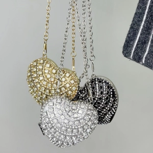 Detailed view of heart-shaped rhinestone necklaces in gold, silver, and black metal