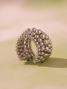Macro detail of silver multi-layer beaded metal ring with polished surface and open design