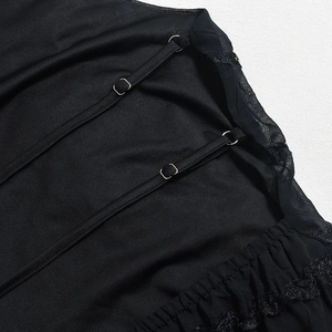 Close-up of black lace fabric with adjustable metal buckle and elastic shoulder straps