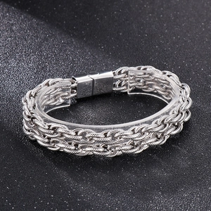 Détail d'un bracelet chaîne de moto en acier inoxydable argenté avec fermoir magnétique sur fond sombre