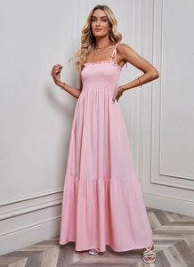 Pink smocked maxi dress featuring delicate tie straps and layered tiered skirt detail