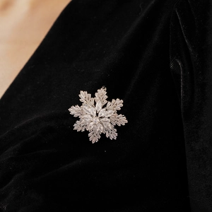 Macro shot of sparkling snowflake brooch with silver base and zirconia crystals