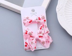 Detail of pink floral handmade ribbon bows with cherry patterns on a display card