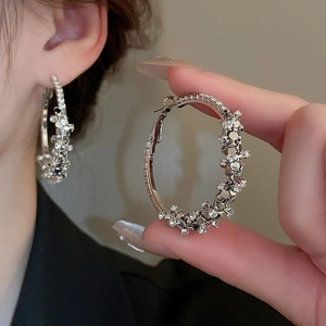 Close-up of oversized silver hoop earrings with shimmering crystal pavé textures