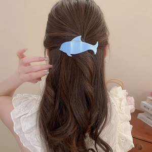 Detail of light blue dolphin acrylic hair claw clip with diamond accents on model hair